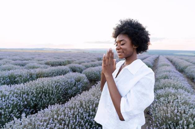 Smiling woman with prayer pose standing in lavender field model released, Symbolfoto, AAZF01141