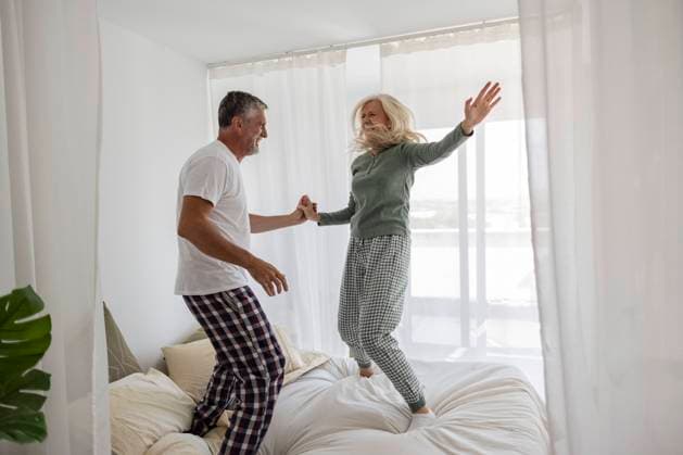 Carefree couple dancing on bed at home model released, Symbolfoto property released, JCCMF10764