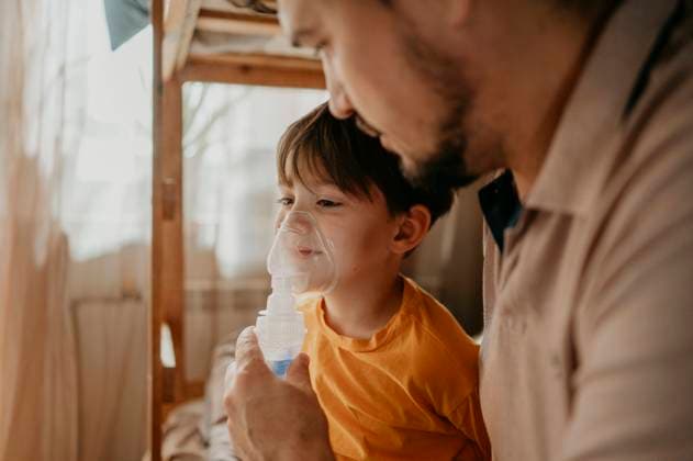 Man assisting son with nebulizer at home model released, Symbolfoto property released, ANAF02223