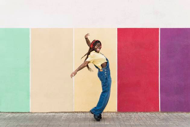 Happy woman dancing in front of multi colored wall model released, Symbolfoto, PNAF06078