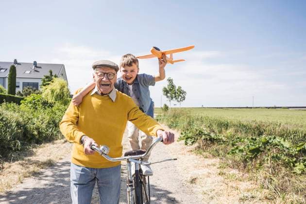 Happy boy holding toy airplane standing on bicycle and enjoying with grandfather model released, Symbolfoto, UUF28966