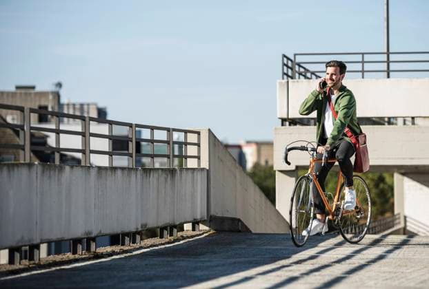 Happy man talking on smart phone and riding bicycle model released, Symbolfoto, UUF30485