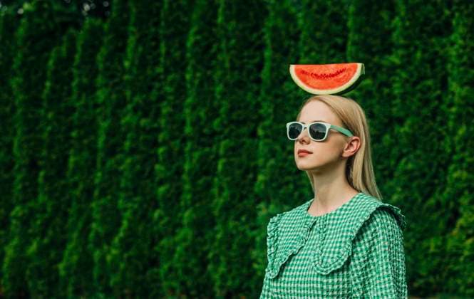 Woman wearing sunglasses standing with watermelon on head in garden model released, Symbolfoto, VSNF01092