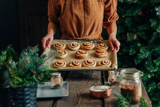 Woman holding cinnamon buns in tray at home model released, Symbolfoto property released, VSNF01397