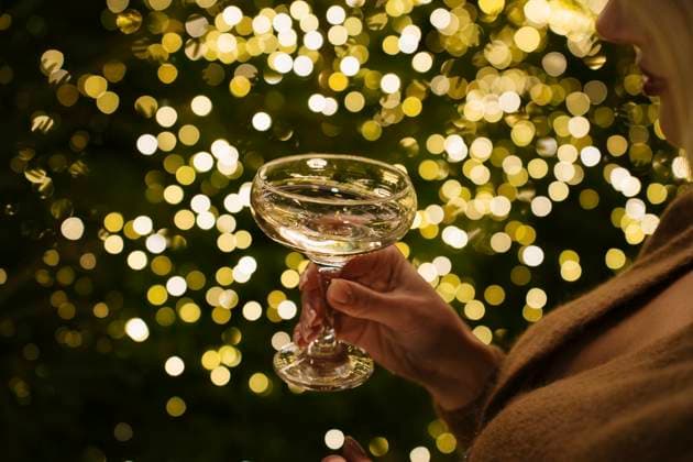 Woman holding champagne glass near illuminated Christmas lights model released, Symbolfoto, YBF00103