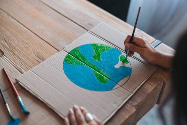 Close-up of a young woman s hands as she paints an earth design on cardboard, symbolizing environmental awareness and care. Model Released EricPanades_ID16562_503318_009 Copyright: xEricxPanadesx RECORD DATE NOT STATED