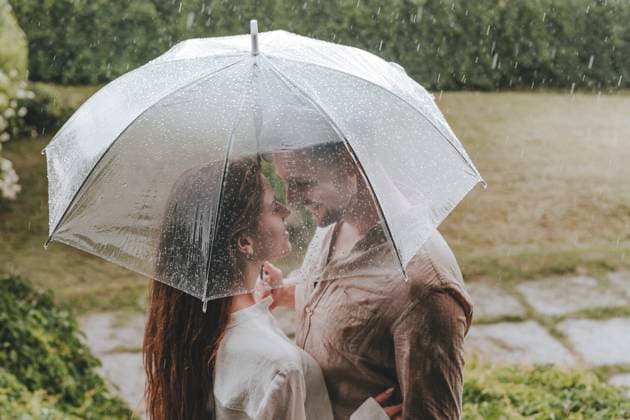 Romantic couple standing with umbrella in rain at garden model released, Symbolfoto, YTF00930