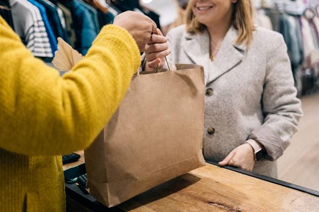 Close-up view of store owner caucasian female hands over a shopping bag to a customer at the checkout counter. Model Released HodeiUnzueta_ID17056_519777_005 Copyright: xHodeixUnzuetax RECORD DATE NOT STATED