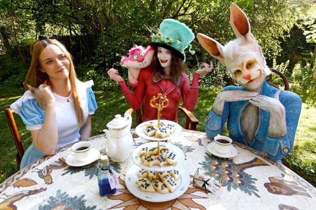 Aus dem FARBKÖRPER Kalender 2024 - Geek Art-Bodypainting und Transformaking: Alice im Wunderland Photoshooting mit Melina als Alice, Julia als verrückter Hutmacher und Janina als das weiße Kaninchen im Czarnecki-Garten in Hameln. Ein Projekt des Fotografen Tschiponnique Skupin und des Bodypainters und Transformakers Enrico Lein