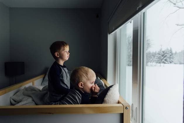 Bright side view of small brothers sitting on bed looking out wi Bismarck, North Dakota, United States CR_KIFR231105C-149094-01 ,model released, Symbolfoto