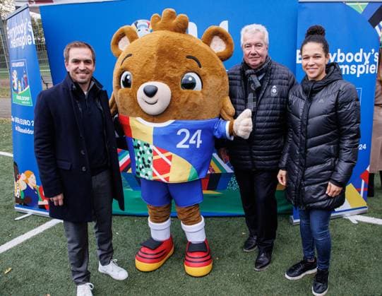 06.11.2023. Düsseldorf. Die UEFA EURO 2024 wird - getreu dem städtischen Motto Everybody s Heimspiel - zu einem Fußballfest für alle Düsseldorferinnen und Düsseldorfer. Die UEFA EURO 2024 soll auch über das Turnier hinaus nachhaltig sichtbare Spuren in der Stadt hinterlassen. Aus diesem Grund besucht Turnierdirektor und Fußball-Weltmeister Philipp Lahm (li.), Celia äaöic (Botschafterin und ehemalige Nationalspielerin, re.), Peter Frymuth (Vizepräsident des Deutschen Fußballbundes und Präsident des Fußballverbandes Niederrhein, 2. v. re.) über 150 Nachwuchskickerinnen und -kicker beim SV Wersten. Hier mit Maskottchen Albärt. Düsseldorf Wersten Nordrhein-Westfalen Deutschland