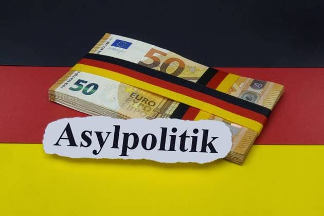 Deutschlandfahne mit Geldbündel und Asylpolitik Deutschlandfahne mit Geldbündel und Asylpolitik, 07.11.2023, Borkwalde, Brandenburg, Auf einer Deutschlandfahne liegt ein Geldbündel mit dem Schriftzug Asylpolitik. *** German flag with bundle of money and asylum policy German flag with bundle of money and asylum policy, 07 11 2023, Borkwalde, Brandenburg, On a German flag lies a bundle of money with the lettering asylum policy