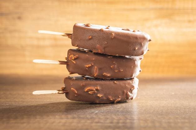 Popsicle, ice cream covered with chocolate on wooden table. Popsicle, ice cream covered with chocolate on the wooden table. Copyright: xZoonar.com JirixHERAx 20405591