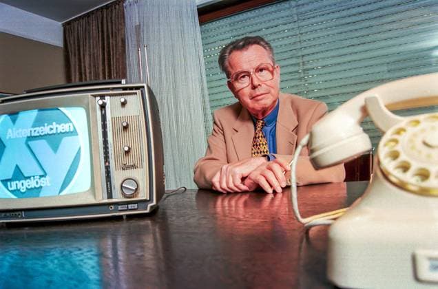 Eduard Zimmermann, Fernsehmoderator von Aktenzeichen X... ungelöst, Unterföhring, September 1997 Deutschland, Unterföhring, 23.09.1997, Eduard Zimmermann, (1929-2009), Fernsehmoderator von Aktenzeichen X... ungelöst, in seinem Büro, mit altem Telefon Siemens W 48 und Fernseher von Graetz, beide aus der Zeit um 1967, als die Sendung im ZDF startete, über Video wird Fernsehbild Aktenzeichen von 1967 eingespielt, von 1967 bis Oktober 1997 moderierte Zimmermann 300 XY-Folgen, Kriminalität, Verbrechen, Verbrechensbekämpfung, Schreibtisch, Fernsehgeschichte, TV-Geschichte, TV-Fahndung, Fahndung im Fernsehen, dunkel, 1990er Jahre, Geschichte, historisch, *** Eduard Zimmermann, television presenter of Aktenzeichen X ungelöst, Unterföhring,