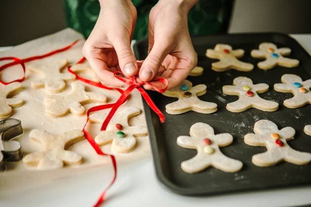 Front view of a woman showing her decorated gingerbread on sheet New York, New York, United States R_INCH231112-1284878-01