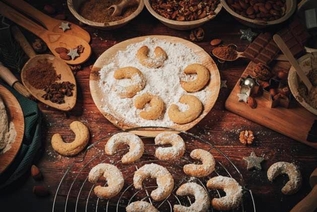 Gebackene Vanillekipferl auf Kuchengitter und in Staubzucker, Backzutaten, Mehl, Zucker, Mandeln, Nüsse, Schokolade, Zimt, Ausstechformen *** baked Vanillekipferl at cake grid and in Powdered sugar, Baking ingredients, Flour, Sugar, Almonds, Nuts, Chocolate, Cinnamon, Ausstechformen Copyright: imageBROKER LucasxSeebacher ibxlse09846176.jpg