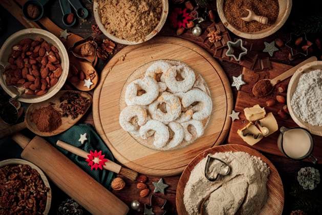 Teller mit Vanillekipferl, Backzutaten, Weihnachtsdeko, Mehl, Zucker, Mandeln, Nüsse, Zimt, Ausstechformen *** Plate with Vanilla crescents, Baking ingredients, Christmas decorations, Flour, Sugar, Almonds, Nuts, Cinnamon, Ausstechformen Copyright: imageBROKER LucasxSeebacher ibxlse09846194.jpg