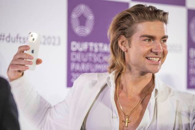 Influencer Jeremy Fragrance filmt sich selbst mit seinem Smartphone auf dem roten Teppich. DUFTSTARS 2023 - Deutscher Parfumpreis Verleihung des deutschen Parfumpreises DUFTSTARS durch die Fragrance Foundation am 16.11.2023, Rheinterrassen, Duesseldorf.