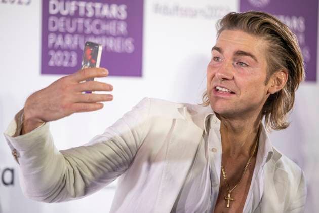 Influencer Jeremy Fragrance filmt sich selbst mit seinem Smartphone auf dem roten Teppich. DUFTSTARS 2023 - Deutscher Parfumpreis Verleihung des deutschen Parfumpreises DUFTSTARS durch die Fragrance Foundation am 16.11.2023, Rheinterrassen, Duesseldorf.
