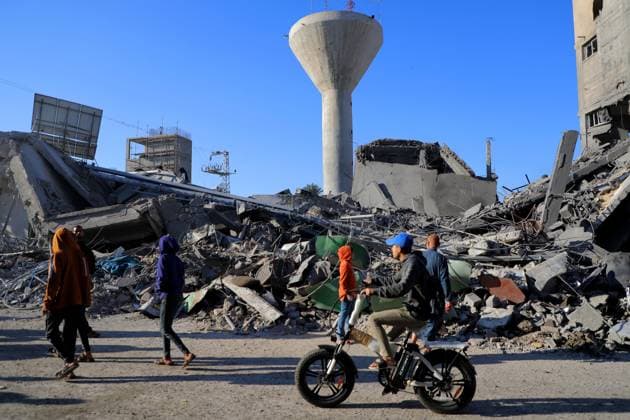(231118) -- GAZA, Nov. 18, 2023 -- People walk past the rubble of buildings destroyed in Israeli military operations in the southern Gaza Strip city of Khan Younis Nov. 17, 2023. Gaza s government media office announced on Friday that the total number of Palestinian deaths in the enclave has exceeded 12,000 since the start of the Israel-Hamas conflict on Oct. 7. (Photo by Xinhua) MIDEAST-GAZA-PALESTINIAN-ISRAELI CONFLICT RizekxAbdeljawad 