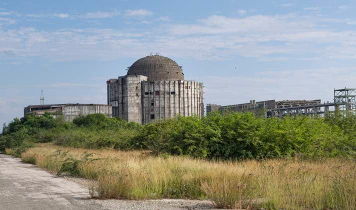Juragua: KKW - das Ende eines Milliardenprojekts. Blick auf die Ruine des Kernkraftwerks (KKW) in Juragua. Das KKW (Baubeginn 1982, geplante Kosten: 750 Mio Dollar) ging nie in Betrieb. Denn mit dem Zerfall der Sowjetunion, die das Großprojekt maßgeblich unterstützte, geriet Kuba in eine schwere Wirtschaftskrise. Im September 1992 verkündete Kubas Präsident Fidel Castro den Baustopp. Seitdem verfällt das unvollendete Kraftwerksprojekt. Wachpersonal sichert das Gelände. Juragua Kuba *** Juragua NPP the end of a billion-dollar project View of the ruins of the nuclear power plant NPP in Juragua Construction began in 1982 at a planned cost of 750 million dollars The NPP never went into operation This is because the collapse of the Sovi