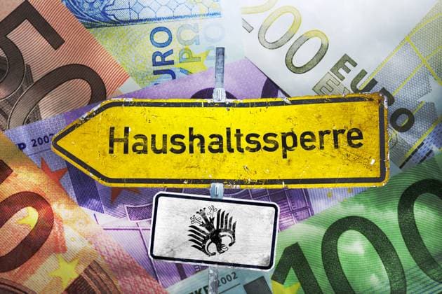 FOTOMONTAGE, Wegweiser mit Aufschrift Haushaltssperre vor Geldscheinen *** FOTOMONTAGE, Signpost with inscription Haushaltssperre vor Geldscheinen ** NUR FUER REDAKTIONELLE ZWECKE ** EDITORIAL USE ONLY **
