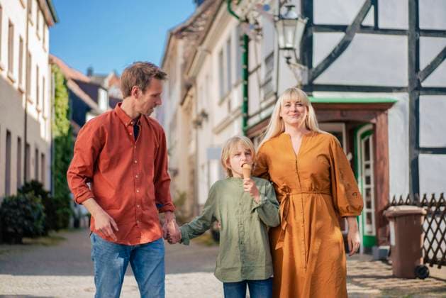 Smiling parents walking with son eating ice cream cone in town model released, Symbolfoto, JOSEF21585