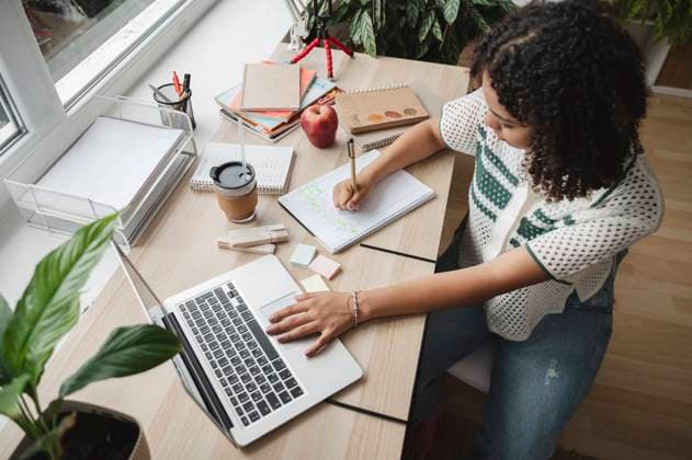 Curly haired teenage girl doing her homework with laptop at home model released, Symbolfoto property released, ALKF00690