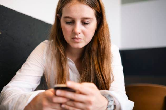 Young businesswoman using mobile phone in office model released, Symbolfoto property released, AMWF01935