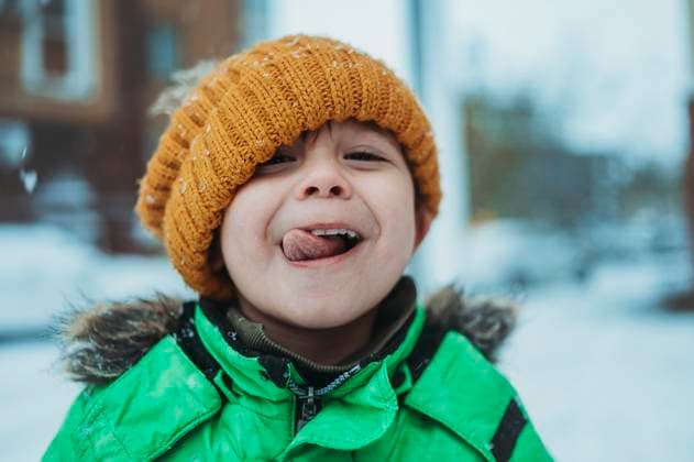 Creative Highlights Symbolbilder Playful boy wearing warm clothes sticking out tongue in winter model released, Symbolfoto, ANAF02395