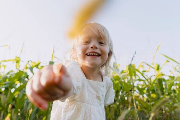 Creative Highlights Symbolbilder Happy girl holding crop in front of plants model released, Symbolfoto, NDEF01229