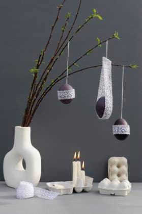 Studio shot of candles burning under laced Easter eggs hanging from twigs in vase, Hamburg Hamburg Deutschland Altes Land GISF00977