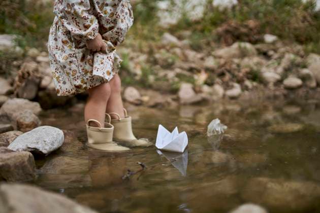 Creative Highlights Symbolbilder Girl wearing rubber boots and playing with paper boat in water puddle model released, Symbolfoto, ANNF00587