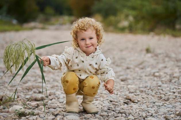 Creative Highlights Symbolbilder Smiling cute girl crouching with twig model released, Symbolfoto, ANNF00605