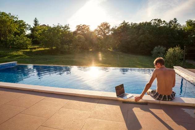 Freelancer sitting with laptop on poolside model released, Symbolfoto property released, MAMF02903