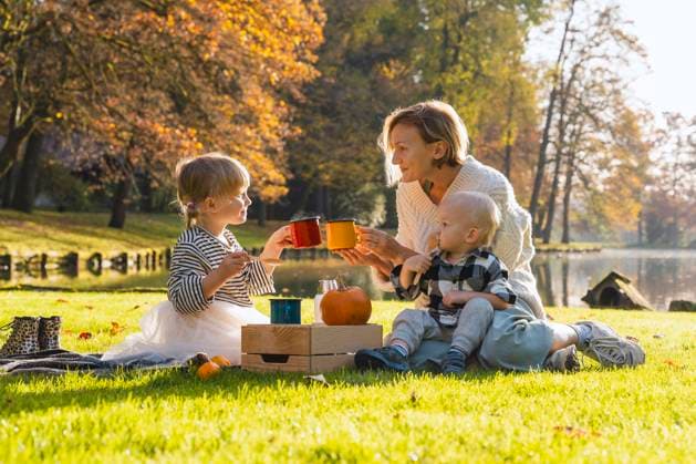 Smiling mother toasting cup with daughter near lake on sunny day model released, Symbolfoto, NDEF01360