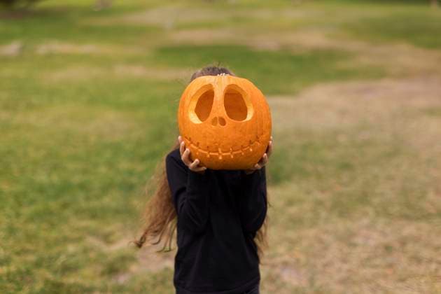 Girl covering face with carved pumpkin model released, Symbolfoto, ONAF00653