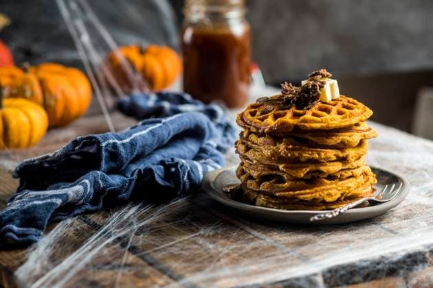 Stack of homemade pumpkin spice waffles with caramelized seeds and syrup, SBDF04661