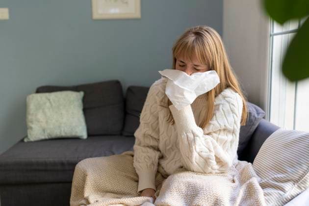 Sick woman blowing nose on tissue paper at home model released, Symbolfoto property released, SVKF01690