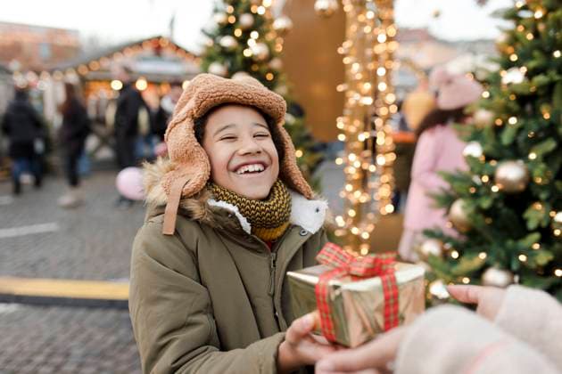 Hands of woman giving gift to boy at Christmas market model released, Symbolfoto, VIVF01104