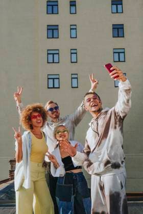 Creative Highlights Symbolbilder Smiling man taking selfie with friends through smart phone on rooftop model released, Symbolfoto property released, YTF01330