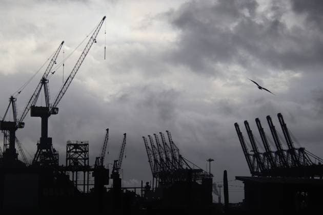 Feature Wirtschaft in Deutschland: Containerbrücken und Werftkräne im Hamburger Hafen vor einem dunkelgrauen Himmel. *** Feature Economy in Germany Container gantry cranes and shipyard cranes in the port of Hamburg against a dark gray sky
