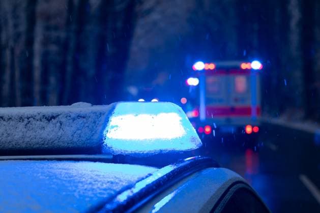 Melle, Deutschland 27. November 2023: Ein Einsatzfahrzeug, Streifenwagen, der Polizei steht mit Blaulicht bei Schneefall in einem Waldstück auf einer Landstraße, im Vordergrund steht ein Rettungswagen, RTW an der Unfallstelle. Landkreis Osnabrück Niedersachsen *** Melle, Germany 27 November 2023 An emergency vehicle, patrol car, of the police stands with blue lights in snowfall in a forest on a country road, in the foreground is an ambulance, RTW at the scene of the accident District of Osnabrück Lower Saxony Copyright: xFotostandx xGelhotx