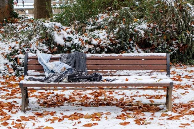 03.12.2023,Kleidungsstücke liegen auf einer schneebedeckten Parkbank. *** 03 12 2023,Pieces of clothing lying on a snow-covered park bench