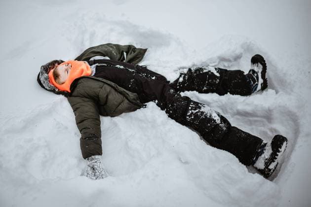 Boy laying in deep snow making snow angel McClure, Illinois, United States R_WEKW231201F3-1298802-01 ,model released, Symbolfoto
