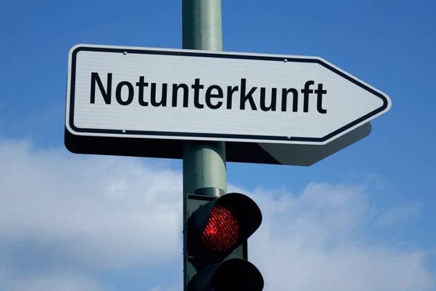 Wegweiser mit Notunterkunft und rote Ampel Wegweiser mit Notunterkunft und rote Ampel, 04.12.2023, Borkwalde, Brandenburg, Über einer roten Ampel befindet sich ein Wegweiser mit dem Schriftzug Notunterkunft. *** Signpost with emergency shelter and red traffic light Signpost with emergency shelter and red traffic light, 04 12 2023, Borkwalde, Brandenburg, Above a red traffic light there is a signpost with the lettering emergency shelter