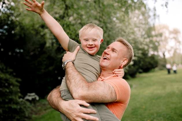 Happy man carrying son with down syndrome at park Sweden, Stockholm, model released Copyright: xMaskotx , MA104430 MA104430