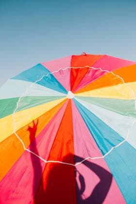 Creative Highlights Symbolbilder A vibrant, multicolored beach umbrella stands out against the azure sky at Santa Monica Pier, creating a joyful summer vibe. Model Released CamilleGirard_ID17695_535209_001 Copyright: xCamillexGirardx