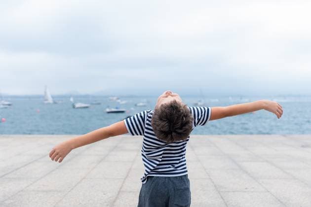 Creative Highlights Symbolbilder Child with outstretched arms stands by the sea, expressing freedom and joy.Title: Joyful child by the sea Model Released HodeiUnzueta_ID17411_528905_003 Copyright: xHodeixUnzuetax