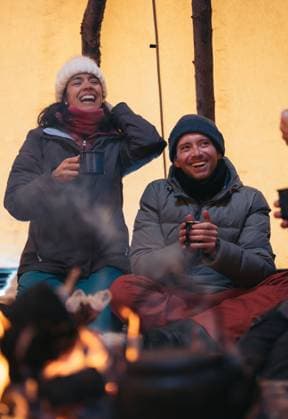 MR_ID16090_14837_CamiloVesga.jpg, MR_ID16090_14838_NataliaLuciaGomez.jpg Cheerful male and female friends with mugs of hot drink spending time together near burning campfire in wintertime Model Released EricPanades_ID16090_489776_048 Copyright: xEricxPanadesx RECORD DATE NOT STATED